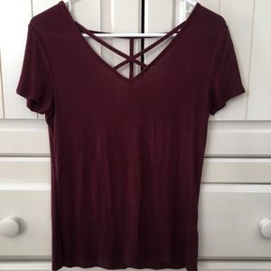 Maroon t shirt with criss-crossing detail.